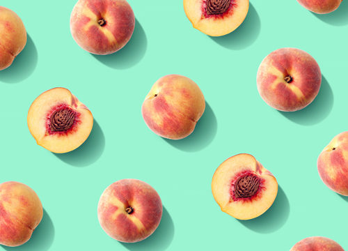 Multiple peaches in the summer on a mint green background