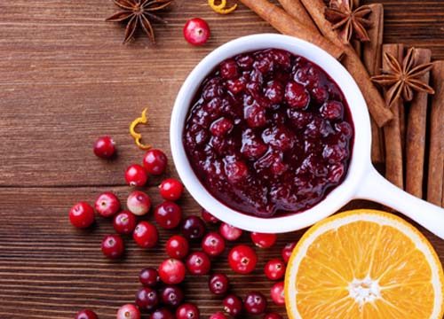 A holiday tradition of cranberries in a cranberry orange sauce on a brown table