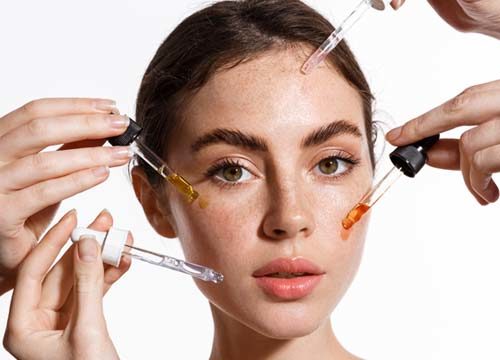 Woman applying medical-grade and over-the-counter skincare products