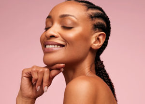 Woman with great skin against a pink background