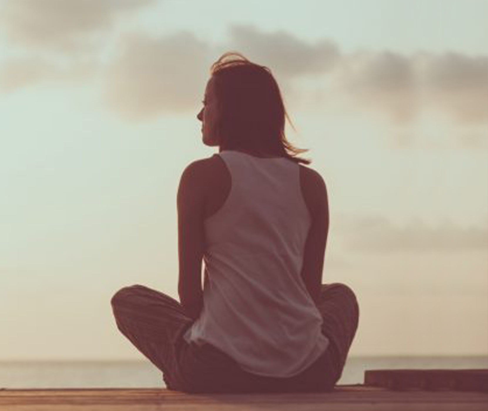 Woman sitting on a dock by water